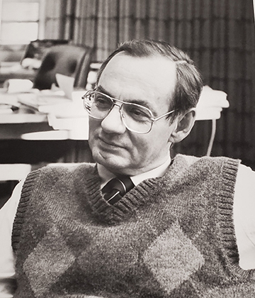 Two contrasting photos of Jennings in plaid vest, seated in his office: a half body pose, looking serious