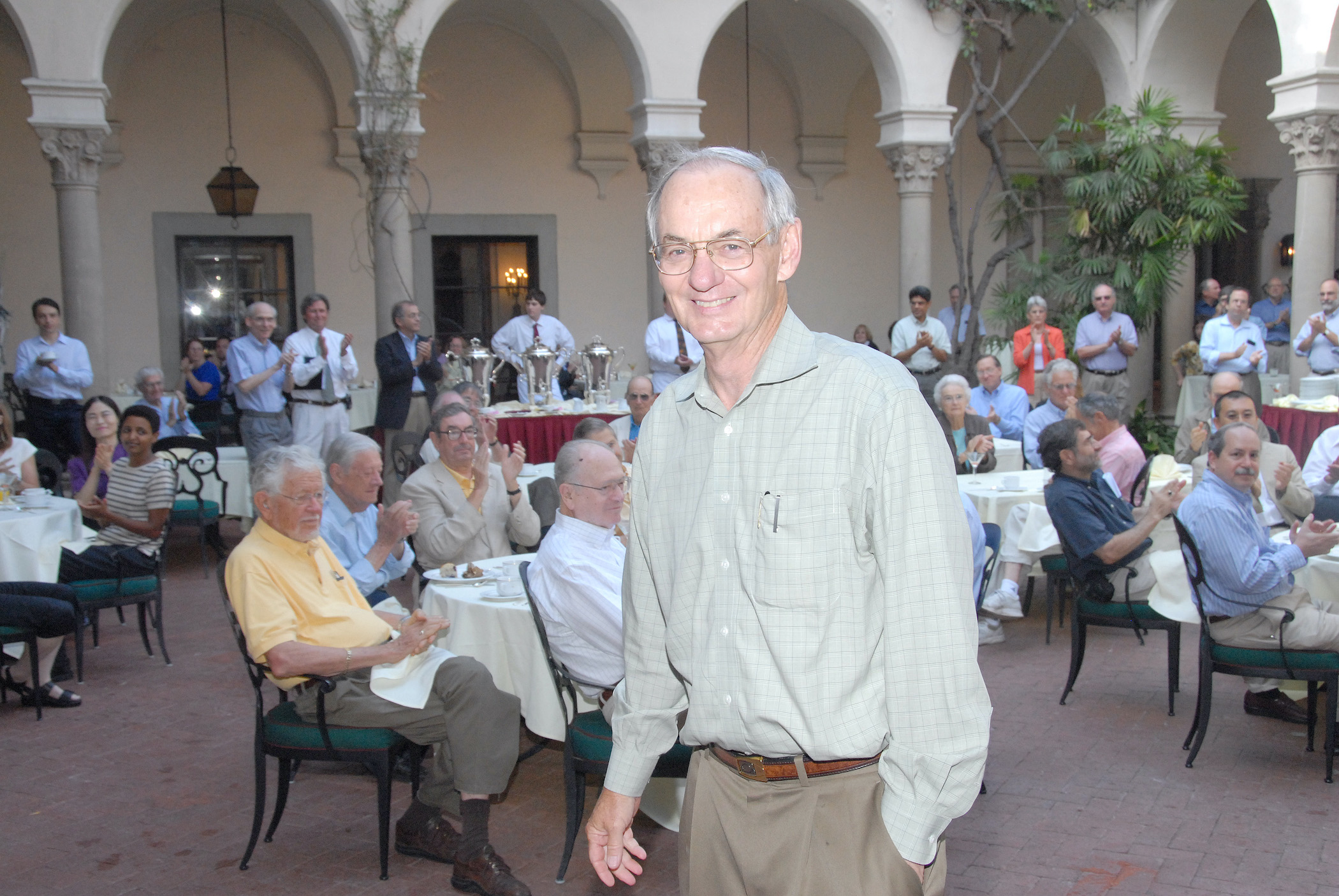 Two views of Jennings at his retirement celebration: Smiling close-up in glasses and a green plaid shirt