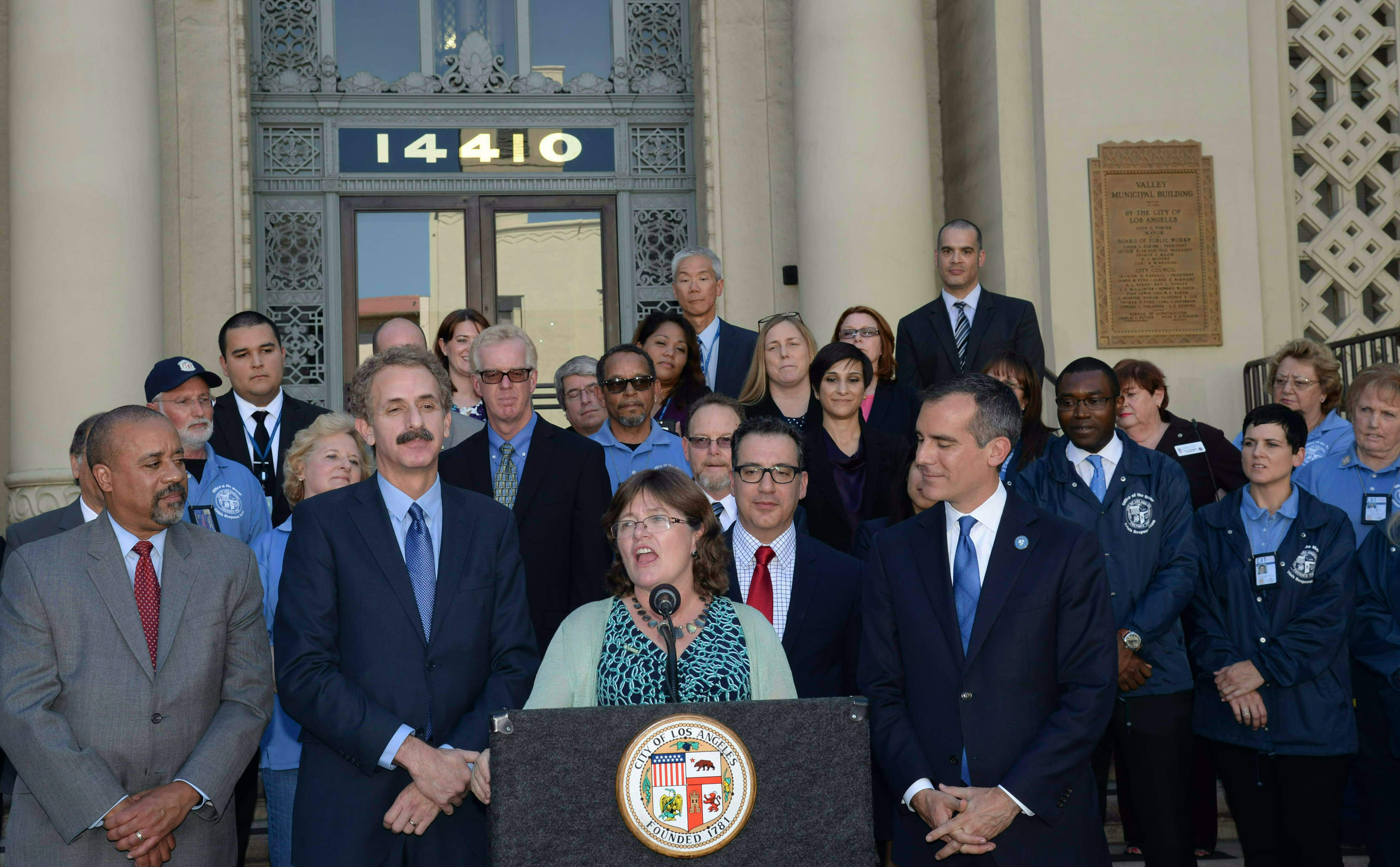 Flanked by General Manager of the Emergency Management Department Jim Featherstone and City Attorney Mike Feuer (left) and LA mayor Eric Garcetti, Jones speaks in front of Van Nuys City Hall just after the LA City Council unanimously approved Resilience by Design’s proposed retrofit legislation. Photo courtesy of Lucy Jones