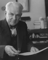Robert A. Millikan seated in front of desk