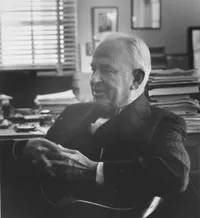 Robert A. Millikan, informal pose seated at desk