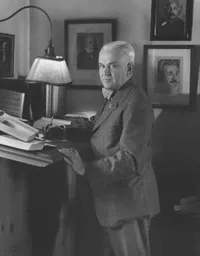 Robert A. Millikan standing at his writing desk