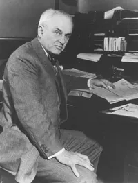 Robert A. Millikan, seated at his desk